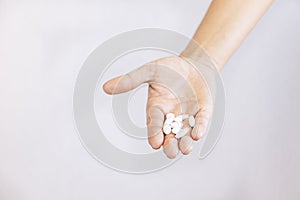 Woman hand holding white pills in hands