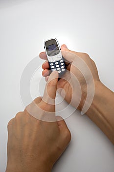 Woman hand holding the world smallest mobile phone with OLED screen in blue plastic body isolated on white