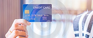 Woman hand holds a blue credit card