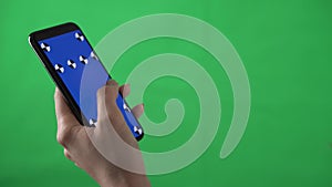 Woman hand holds mockup phone blue screen on green background swipes to left on chromakey