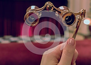 Woman hand holds opera glasses photo