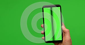 Woman hand holds a smartphone with greeen screen