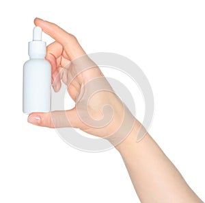 Woman hand holds a white cosmetic bottle, isolated on white background close-up, template for cosmetics ads