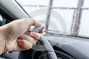 Woman hand inside the car, driver using remote control to open the automatic gate while leaving home, security system and save photo