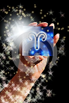 Woman hand keeping a blue card with zodiac symbol of Aries like astrology concept