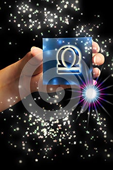 Woman hand keeping a blue card with zodiac symbol of Libra like astrology concept