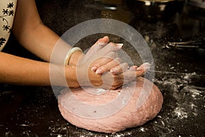 Woman hand kneading bread dough