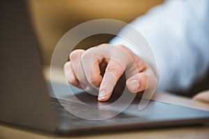 woman hand on laptop touchpad close up