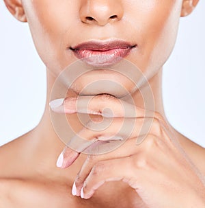 Woman hand, lips and beauty closeup with makeup, face and lipstick glow in studio. Mouth, skincare and manicure of a