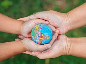 Woman hand and little giel haand holding the globe. Safe the Ear