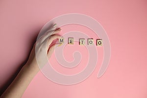 Woman hand making MeToo word with wooden alphabet on pink background, used for concept of sexual harrassment