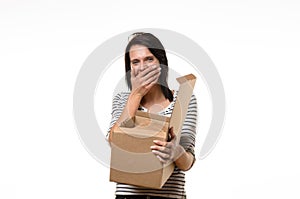 Woman with hand on mouth while holding box