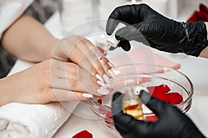 Woman hand nail care and manicure. Closeup of beautiful female hands applying transparent nail polish