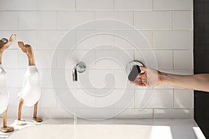 Woman hand open built in wall chrome water tap to fill bathtub