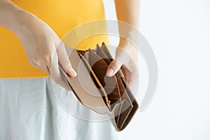 Woman hand open empty brown leather wallet , money in pocket on white background