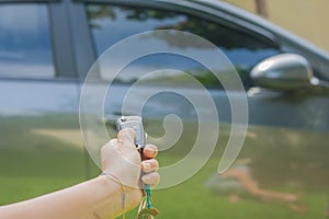 Woman hand open hers car with car remote key.