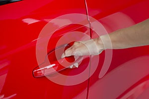 Woman hand on open the new red car door background