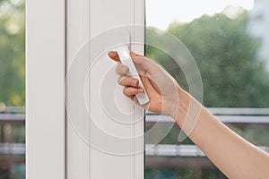 Woman hand open plastic window in living room