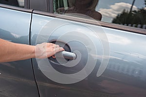 Woman hand opening car door close up.