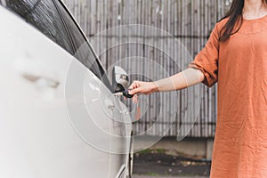 Woman hand opening car door with key.