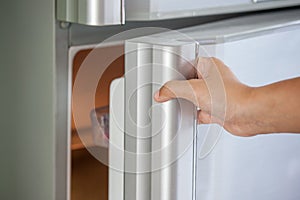 Woman hand opening refrigerator door