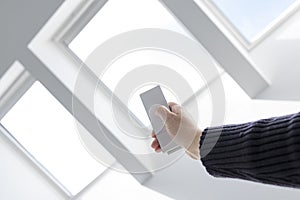 Woman Hand opening roof windows of a house with remote controller
