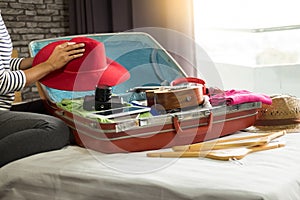 Woman hand packing a luggage for a new journey and travel for a