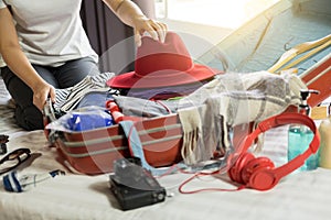 Woman hand packing a luggage for a new journey and travel for a long weekend