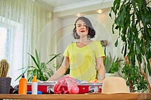 Woman hand packing suitcase, put snorkeling, diving mask