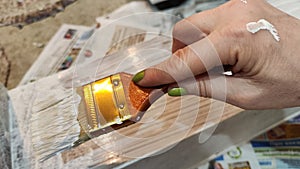 Woman hand painting on wooden boards with Brush full of white paint. Painting of new wood board or furniture and old