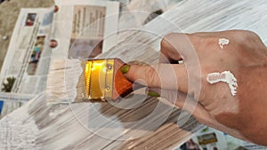 Woman hand painting on wooden boards with Brush full of white paint. Painting of new wood board or furniture and old