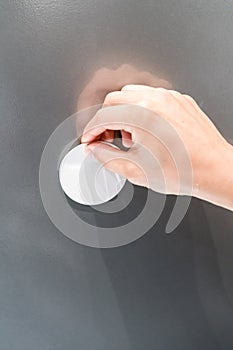 Woman hand pasting white magnet on grey metal board