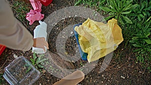 Woman hand picking trash at park cleanup closeup. Volunteer collecting litter