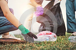 woman hand picking up garbage plastic bottle for cleaning at park