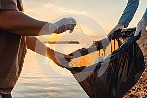 woman hand picking up garbage plastic bottle for cleaning at park