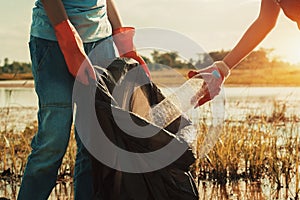 woman hand picking up garbage plastic for cleaning at river