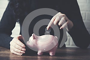 Woman hand piggy bank and coin