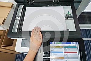 Woman hand place paper sheet on printer plate for scanning