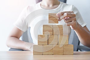 Woman hand placing wood block on the building. Leadership, Business process planning, Risk Management and strategy Concepts