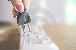 Woman hand plug in electric on multiple socket