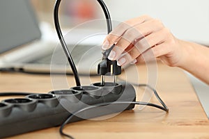 Woman hand plugging electric plug a in a socket