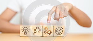 Woman hand pointing gear with lightbulb, dartboard, magnifying and Gear icon block. business planning process, goal, strategy,