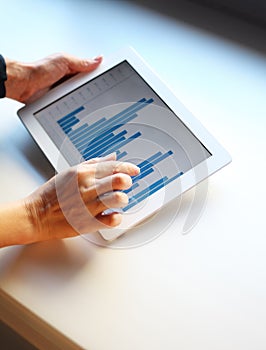 Woman hand pointing at touchscreen with business graph