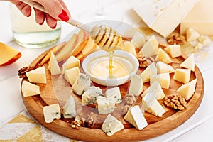 Woman Hand Pouring Honey to Cheese Board Gourmet