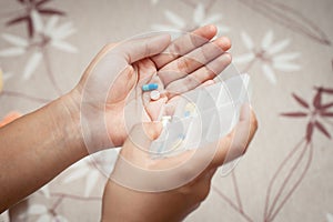 Woman hand pouring pills from a pill reminder box