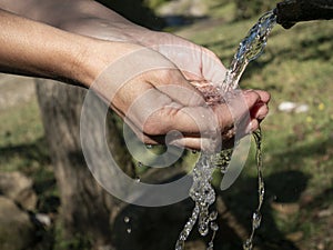 Woman hand pouring Water on nature background