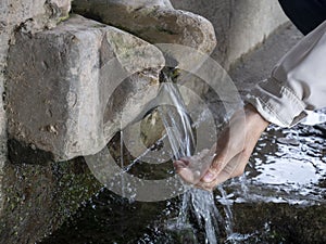 Woman hand pouring Water on nature spring