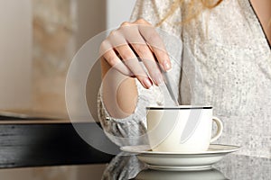 Woman hand preparing a cup of coffee