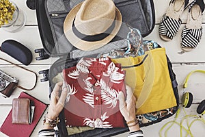 Woman hand preparing summer luggage