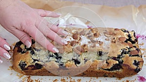 a woman hand presses on a pie Strudel with apples, ice crean and berry sauce on plate